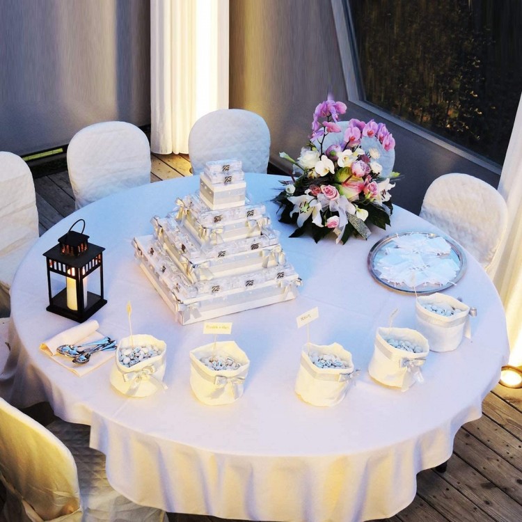 White 90-inch round tablecloth made of durable polyester, ideal for weddings and banquets, elegantly covering a table.